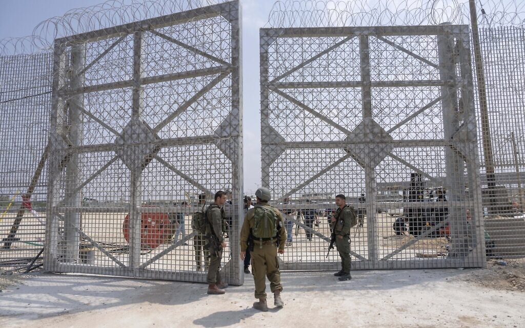 Des soldats israéliens rassemblés à proximité d'un barrage dans une zone d'inspection pour les camions transportant de l'aide humanitaire à destination de la bande de Gaza, du côté israélien du point de passage d'Erez à Gaza, le 1er mai 2024. (Crédit : Ohad Zwigenberg/AP)