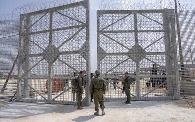 Des soldats israéliens rassemblés à proximité d'un barrage dans une zone d'inspection pour les camions transportant de l'aide humanitaire à destination de la bande de Gaza, du côté israélien du point de passage d'Erez à Gaza, le 1er mai 2024. (Crédit : Ohad Zwigenberg/AP)