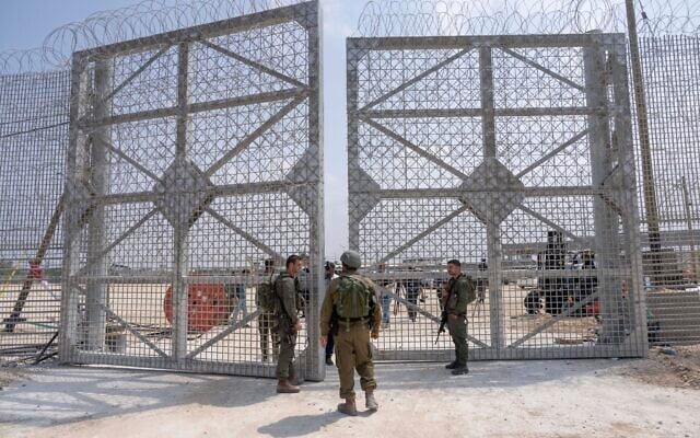 Des soldats israéliens rassemblés à proximité d'un barrage dans une zone d'inspection pour les camions transportant de l'aide humanitaire à destination de la bande de Gaza, du côté israélien du point de passage d'Erez à Gaza, le 1er mai 2024. (Crédit : Ohad Zwigenberg/AP)