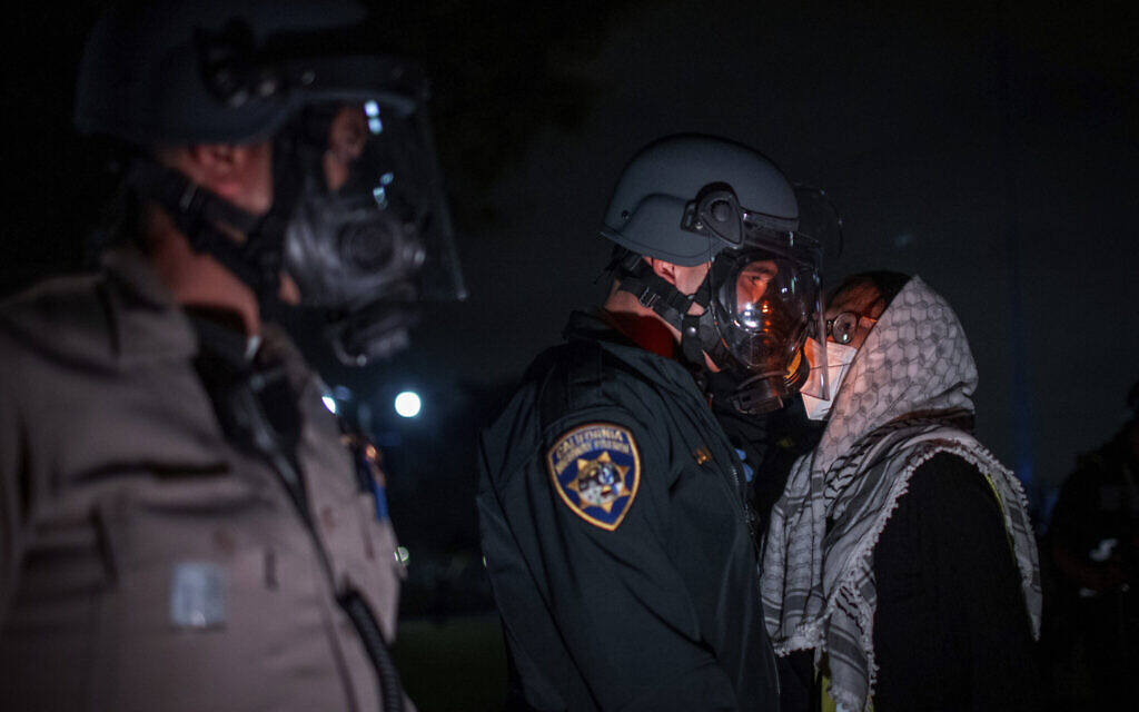  Un manifestant affrontant la police lors d'un campement anti-Israël et pro-palestinien, à l'UCLA, à Los Angeles, le 1er mai 2024. (Credit : Ethan Swope/AP)