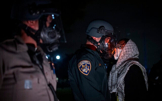  Un manifestant affrontant la police lors d'un campement anti-Israël et pro-palestinien, à l'UCLA, à Los Angeles, le 1er mai 2024. (Credit : Ethan Swope/AP)