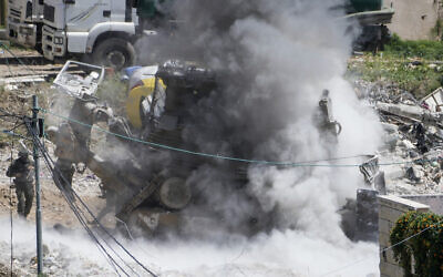 Des soldats israéliens se mettant à l'abri lors d'une opération militaire dans la ville palestinienne de Dayr al-Ghusun, à proximité de la ville de Tulkarem, en Cisjordanie, le 4 mai 2024. (Crédit : Majdi Mohammed/AP)