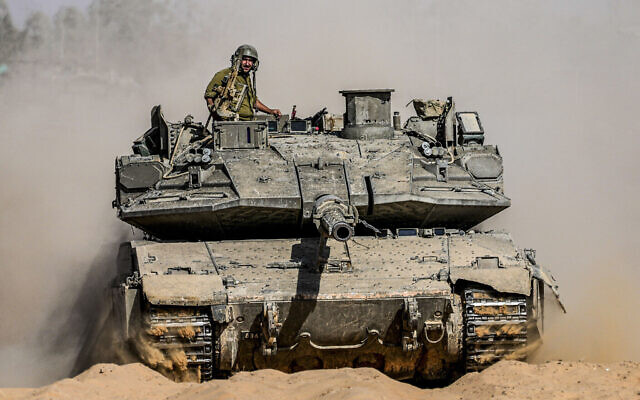 Des soldats israéliens conduisant un char d'assaut sur un terrain de rassemblement près de la frontière avec la bande de Gaza, dans le sud d'Israël, le 5 mai 2024. (Crédit : Tsafrir Abayov/AP)