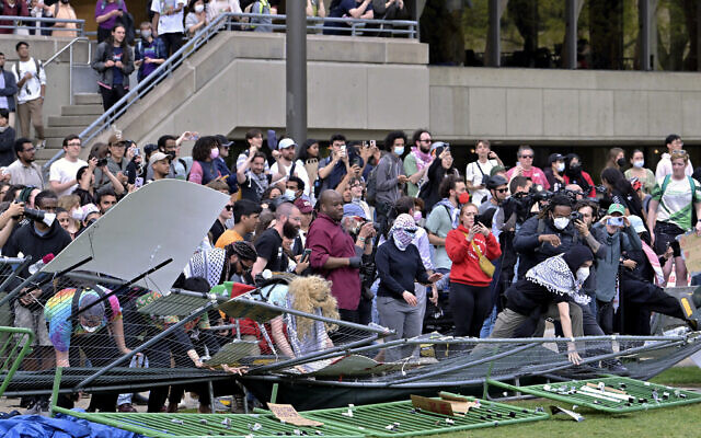Des manifestants franchissant des barricades qui avaient été érigées à l'extérieur d'un campement anti-Israël, au MIT, à Cambridge, dans le Massachusetts, le 6 mai 2024. (Crédit : Josh Reynolds/AP) Des manifestants franchissant des barricades qui avaient été érigées à l'extérieur d'un campement anti-Israël, au MIT, à Cambridge, dans le Massachusetts, le 6 mai 2024. (Crédit : Josh Reynolds/AP)