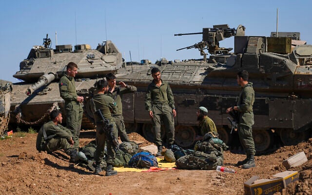 Illustration : Des soldats israéliens travaillant sur des véhicules militaires blindés sur un terrain de rassemblement près de la frontière entre Israël et Gaza, dans le sud d'Israël, le 8 mai 2024. (Crédit : Tsafrir Abayov/AP) Illustration : Des soldats israéliens travaillant sur des véhicules militaires blindés sur un terrain de rassemblement près de la frontière entre Israël et Gaza, dans le sud d'Israël, le 8 mai 2024. (Crédit : Tsafrir Abayov/AP)