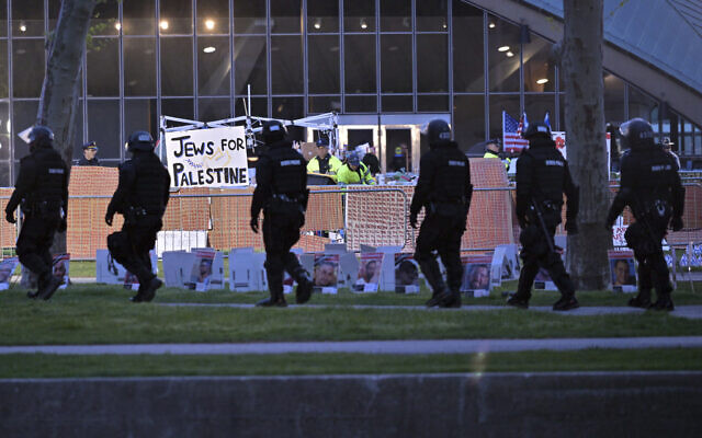 Une ligne de policiers en tenue anti-émeute passe devant la police qui démantèle un campement anti-israélien au MIT, avant l'aube du 10 mai 2024, à Cambridge, Massachusetts. (Crédit : AP Photo/Josh Reynolds) Une ligne de policiers en tenue anti-émeute passe devant la police qui démantèle un campement anti-israélien au MIT, avant l'aube du 10 mai 2024, à Cambridge, Massachusetts. (Crédit : AP Photo/Josh Reynolds)