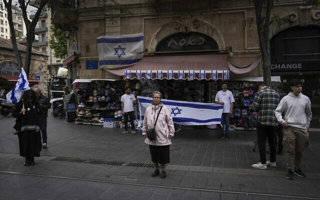 Les gens s'immobilisent pour observer deux minutes de silence à l'occasion de Yom HaZikaron, à Jérusalem, le lundi 13 mai 2024. (Crédit : AP/Mahmoud illean)