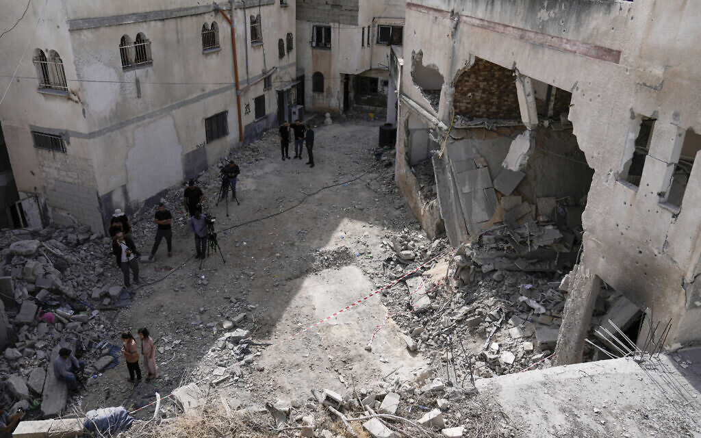 Des Palestiniens inspectant les dégâts causés par une frappe aérienne israélienne dans le camp de réfugiés de Jénine, en Cisjordanie, le 18 mai 2024. (Crédit : Majdi Mohammed/AP)