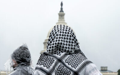 Un homme portant un keffieh regardant le Capitole américain lors d'un rassemblement pro-palestinien et anti-Israël, sur le National Mall, à Washington, le 18 mai 2024. (Crédit : Jacquelyn Martin/AP)