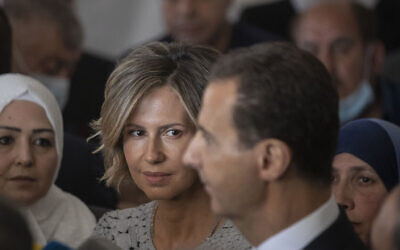 La première dame syrienne Asma Assad (deuxième à gauche) écoutant son époux, le dictateur syrien Bashar el-Assad, s'adressant aux médias après avoir voté dans un bureau de vote lors des élections présidentielles, à Douma, dans la région de la Ghouta orientale, près de la capitale syrienne Damas, en Syrie, le 26 mai 2021. (Crédit : Hassan Ammar/AP)