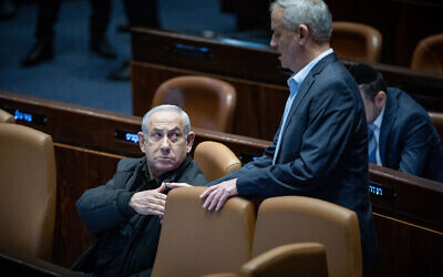 Le Premier ministre Benjamin Netanyahu serre la main de Benny Gantz à la Knesset, à Jérusalem, le 25 décembre 2023. (Crédit : Yonatan Sindel/Flash90)