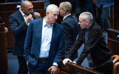 Le ministre Benny Gantz s'entretenant avec le député Chilli Tropper lors d'un vote sur le budget de l'État, à la Knesset, à Jérusalem, le 7 février 2024. (Crédit : Yonatan Sindel/Flash90)