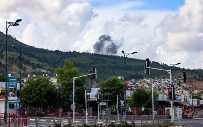 De la fumée s’élevant d'une roquette tirée du Liban vers le nord d'Israël, vue de Kiryat Shmona, le 5 mai 2024. (Crédit : David Cohen/Flash90)