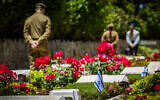 Des soldats de l'armée israélienne plaçant des drapeaux israéliens sur des tombes de soldats lors d'une cérémonie de pose de drapeaux au cimetière militaire du mont Herzl, à Jérusalem, à l'approche de Yom HaZikaron, le 8 mai 2024. (Crédit : Yonatan Sindel/Flash90)