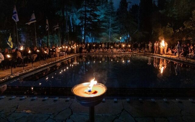 Des scouts israéliens de Modiin allument des bougies lors d'une cérémonie commémorant les soldats israéliens tombés au combat, à la veille de Yom HaZikron, au cimetière militaire du Mont Herzl à Jérusalem, le 12 mai 2024. (Crédit : Yonatan Sindel/Flash90)