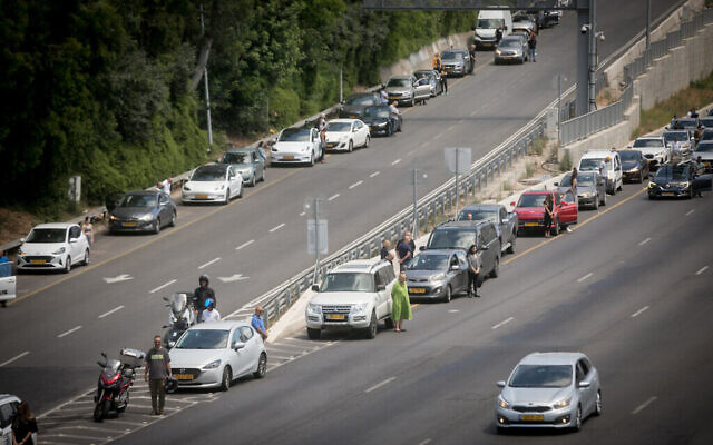 La sirène de deux minutes retentit à travers Israël, marquant Yom HaZikaron, sur l'autoroute Ayalon à Tel Aviv, le 13 mai 2024. (Crédit : Miriam Alster/Flash90)