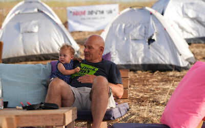 Des résidents de communautés évacuées dans le nord d'Israël et des sympathisants installés dans un village de tentes pour demander au gouvernement de les autoriser à rentrer chez eux, à la jonction d'Amiad, dans le nord d'Israël, le 23 mai 2024. (Crédit : Ayal Margolin/Flash90)
