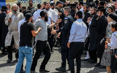 La police repousse des ultra-orthodoxes qui tentent d'entrer au tombeau du rabbin Shimon bar Yochai lors de la fête juive dfe Lag BaOmer, sur le mont Meron, le 26 mai 2024. (Crédit : David Cohen/Flash90)