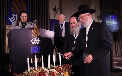 Matisyahu Grossinger, président du conseil d'administration des Archives du Kiddouch Hachem, musée ultra-orthodoxe de la Shoah à Bnei Brak, allume une bougie commémorative lors d'une cérémonie commémorative le 7 mai 2024. (Yaakov Nachumi)