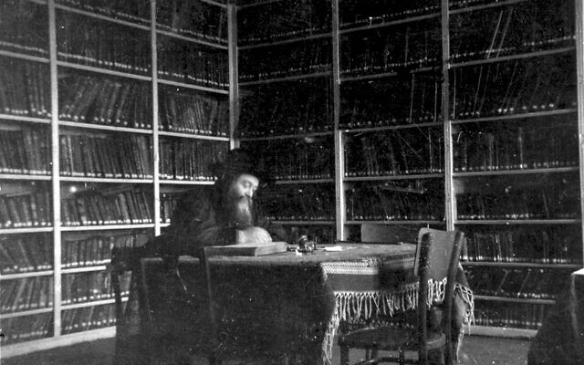Le rabbin Meir Shapiro assis dans la bibliothèque de la Yeshiva Chachmei Lublin, une photographie prise entre l'ouverture de la Yeshiva, en 1930, et sa mort, en 1933.  Le sort réservé à la yeshiva sous les nazis reste mystérieux. (Autorisation :  Grodzka Gate-NN Theater Center)