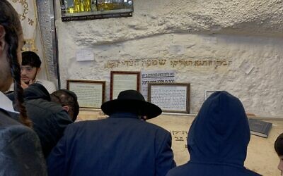 Des pèlerins se recueillent sur la tombe du grand prêtre de l'époque du Second Temple, Shimon HaTzadik, dans le quartier de Sheikh Jarrah à Jérusalem-Est à l'occasion de Lag BaOmer, le 25 mai 2024. (Charlie Summers/Times of Israel)