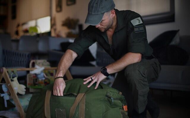 Micha Shtiebel, réserviste de Tsahal de la brigade Alexandroni, prépare son sac pour l'armée contenant des équipements qu'il a achetés lui-même ou qu'il a reçus de donateurs, dans sa maison du centre d'Israël, le 26 mai 2024. (Crédit : Yakov Binyamin via la JTA)