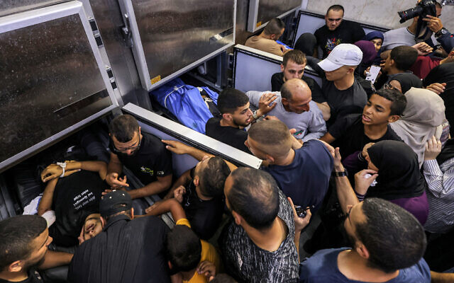 Rassemblement de personnes se recueillant devant une morgue contenant les corps de trois Palestiniens tués lors d'un raid de l'armée israélienne à Jénine en Cisjordanie, le 6 juin 2024. (Crédit : Jaafar Ashtiyeh/AFP) Rassemblement de personnes se recueillant devant une morgue contenant les corps de trois Palestiniens tués lors d'un raid de l'armée israélienne à Jénine en Cisjordanie, le 6 juin 2024. (Crédit : Jaafar Ashtiyeh/AFP)