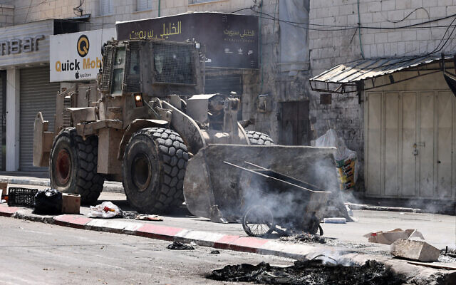 Un bulldozer de l'armée israélienne opère à l'entrée de Jénine en Cisjordanie, lors d'un raid le 13 juin 2024. (Crédit : Zain Jaafar/AFP)