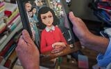 Un homme tient un exemplaire de la version graphique du "Journal d'Anne Frank", du scénariste-réalisateur israélien Ari Folman et de l'illustrateur David Polonsky, à Paris le 18 septembre 2017. (Crédit : Stringer/AFP via Getty Images vita JTA)