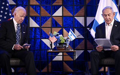 Le président américain Joe Biden, à gauche, regardent ses notes en écoutant le Premier ministre Benjamin Netanyahu lors d'une réunion à Tel Aviv, le 18 octobre 2023. (Crédit : Brendan Smialowski / AFP)