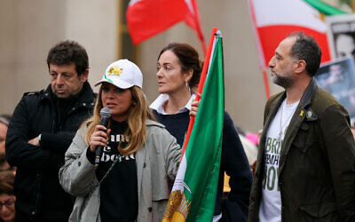 Mona Jafarian (au centre), Franco-Iranienne présidente et cofondatrice du collectif Femme Azadi (Woman Freedom), entourée du chanteur et auteur-compositeur français Patrick Bruel et du publicitaire français Frank Tapiro, à un rassemblement organisé par le Conseil représentatif des institutions juives de France (CRIF) appelant à la libération des otages détenus à Gaza depuis les attaques du 7 octobre 2023 menées par le Hamas contre Israël, sur l'esplanade du Trocadéro, à Paris, le 7 avril 2024. (Crédit : Thomas SAMSON / AFP)