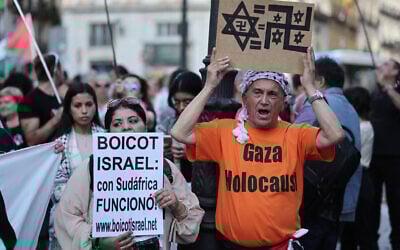 Des manifestants brandissant des pancartes sur lesquelles on peut lire « Boycottez Israël, ça a marché avec l'Afrique du Sud » lors d'une manifestation anti-Israël, devant le ministère des Affaires étrangères, à Madrid, le 27 mai 2024. (Crédit : Thomas Coex/AFP)