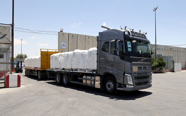 Un camion transportant de l'aide humanitaire à destination de la bande de Gaza traversant le poste-frontière de Kerem Shalom entre le sud d'Israël et Gaza, le 30 mai 2024. (Crédit : Jack Guez/AFP) Un camion transportant de l'aide humanitaire à destination de la bande de Gaza traversant le poste-frontière de Kerem Shalom entre le sud d'Israël et Gaza, le 30 mai 2024. (Crédit : Jack Guez/AFP)