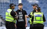 Un manifestant portant un tee-shirt avec l'inscription "Carton rouge pour Israël" s'est enchaîné au poteau de but avant le match de football de qualification à l'Euro 2025 féminin entre l’Ecosse et Israël, au stade Hampden Park de Glasgow, le 31 mai 2024. (Crédit : Andy Buchanan/AFP)