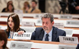 Riyad Awaja, du conseil des affaires socio-économiques à la Mission permanente d'observation de l'État de Palestine, plaçant une pancarte indiquant « Palestine » devant lui alors qu'il prend place parmi les États membres lors de la huitième séance plénière de la 77e Assemblée mondiale de la santé à Genève, en Suisse, le 1er juin 2024. (Crédit : Pierre Albouy/Organisation mondiale de la santé/AFP)