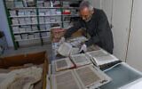 Said al-Barouni, bibliothécaire tunisien de 74 ans et membre de l'Ibadisme, trie de vieux manuscrits pour les numériser, dans sa bibliothèque de Djerba, le 27 mai 2024. (Crédit  FETHI BELAID / AFP)
