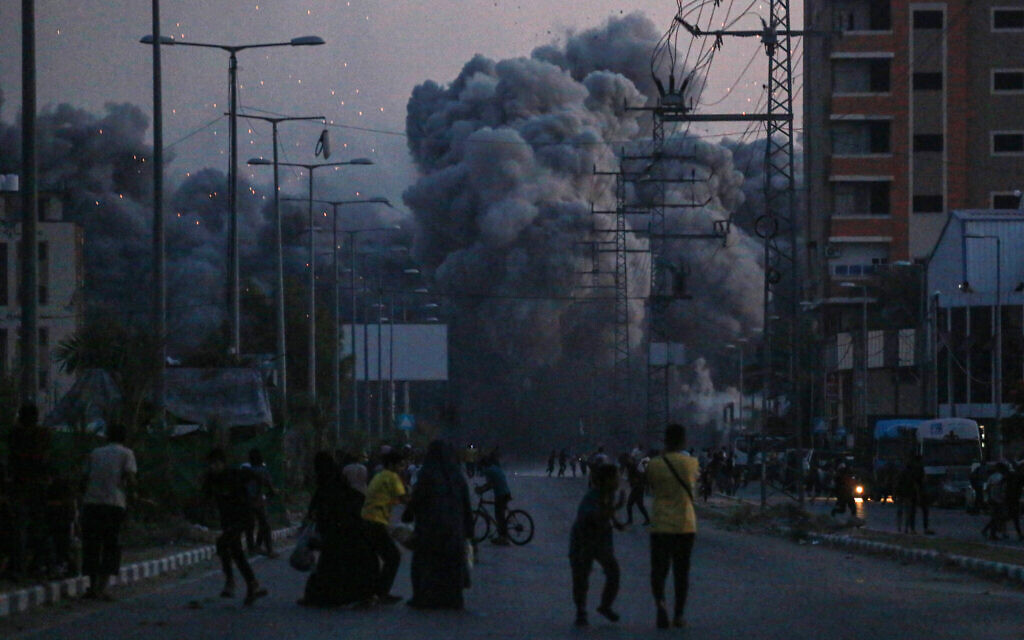 Des Palestiniens observent la fumée qui se dégage d'une frappe aérienne israélienne à Deir al-Balah, dans le centre de la bande de Gaza, le 6 juin 2024. (Crédit : Bashar Taleb/AFP)
