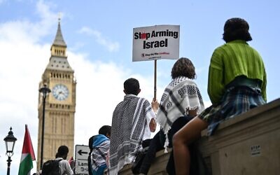 Des manifestants anti-Israël brandissant des pancartes à la fin de la "Marche nationale pour Gaza", devant la Tour Elizabeth, plus connue sous le nom de la cloche de l'horloge "Big Ben", au Palais de Westminster, qui abrite les Chambres du Parlement, dans le centre de Londres, le 8 juin 2024. (Crédit : Justin Tallis/AFP)