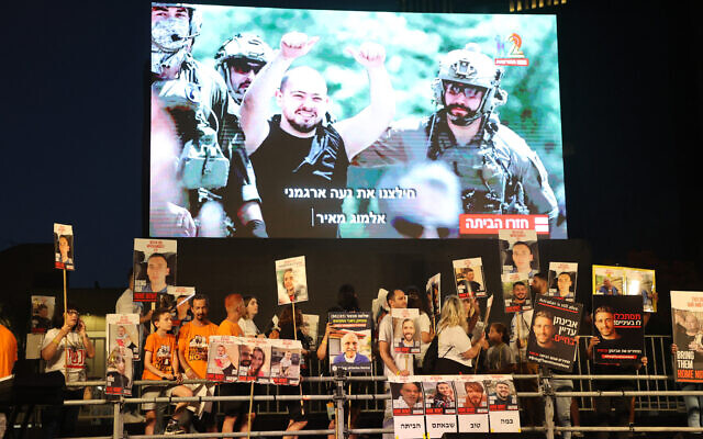 Les images d'otages libérés par le Hamas projetées pendant une manifestation en faveur de la libération des captifs du Hamas qui se trouvent à Gaza depuis le 7 octobre à Tel Aviv, le 8 juin 2024. (Crédit : Gil Magen-Cohen/AFP)
