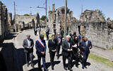 Le président français Emmanuel Macron et le président allemand Frank-Walter Steinmeier marchent dans une rue devant des ruines de bâtiments lors du 80e anniversaire du massacre de 643 personnes par les forces allemandes nazies, à Oradour-sur-Glane, dans le sud-ouest de la France, le 10 juin 2024.  (Crédit : Ludovic MARIN / POOL / AFP)