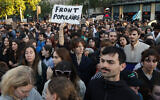 Un manifestant brandissant une pancarte portant l'inscription "Front populaire" lors d'une manifestation sur la place de la République contre la victoire du parti d'extrême droite français Rassemblement national (RN) aux élections européennes, prenant une position de force dans les élections législatives anticipées convoquées par le président français après les résultats des élections, à Paris, le 10 juin 2024. (Crédit : Geoffroy Van Der Hasselt/AFP)