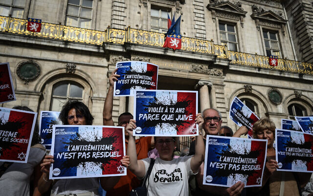 Des manifestants tenant des pancartes sur lesquelles on peut lire "L'antisémitisme n'est pas résiduel", "+1 000 % d'actes antisémites, ce ne sont pas que des chiffres", "Nos vies valent plus que le conflit importé" et "Fille juive violée, République en danger" alors qu'ils se rassemblent pour condamner le viol collectif antisémite présumé d'une jeune fille de 12 ans, lors d'un rassemblement sur la Place des Terreaux, à Lyon, dans le centre-est de la France, le 19 juin 2024. (Crédit : Jean-Philippe Ksiazek/AFP) Des manifestants tenant des pancartes sur lesquelles on peut lire "L'antisémitisme n'est pas résiduel", "+1 000 % d'actes antisémites, ce ne sont pas que des chiffres", "Nos vies valent plus que le conflit importé" et "Fille juive violée, République en danger" alors qu'ils se rassemblent pour condamner le viol collectif antisémite présumé d'une jeune fille de 12 ans, lors d'un rassemblement sur la Place des Terreaux, à Lyon, dans le centre-est de la France, le 19 juin 2024. (Crédit : Jean-Philippe Ksiazek/AFP)