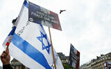 Des manifestants brandissant une pancarte "violée parce que juive" et un drapeau israélien pour condamner le viol collectif antisémite présumé d'une jeune fille juive de 12 ans, sur la Place de l'Hôtel de Ville de Paris, le 19 juin 2024. (Crédit : Alain Jocard/AFP)