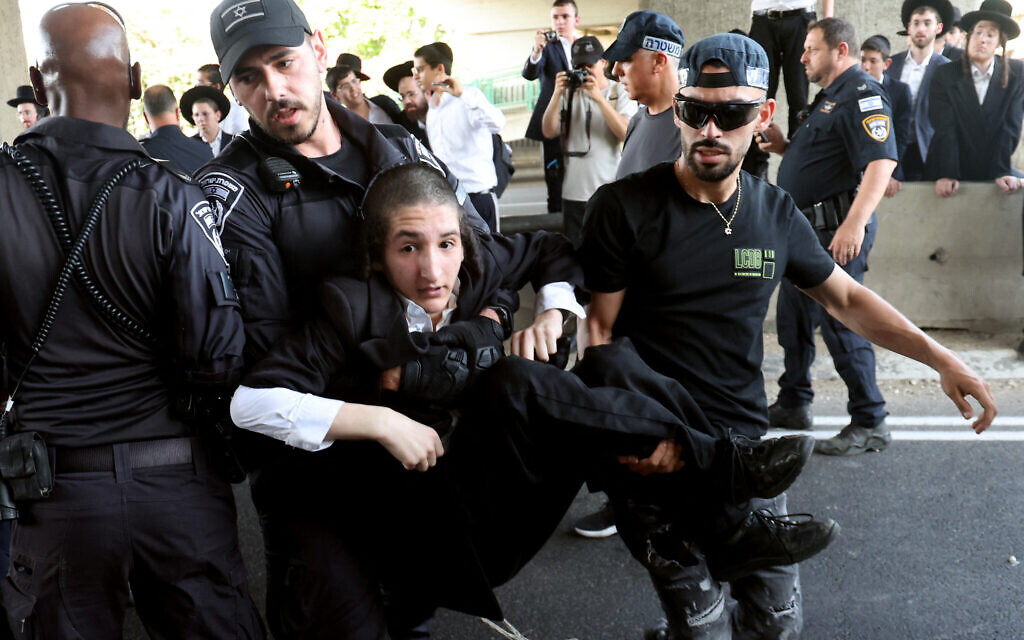 La police disperse des Juifs ultra-orthodoxes bloquant une autoroute pendant une manifestation contre le service militaire à Bnei Brak, dans le centre d'Israël, le 20 juin 2024. (Crédit : Jack Guez/AFP) La police disperse des Juifs ultra-orthodoxes bloquant une autoroute pendant une manifestation contre le service militaire à Bnei Brak, dans le centre d'Israël, le 20 juin 2024. (Crédit : Jack Guez/AFP)