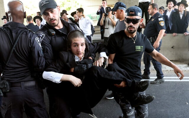 La police disperse des Juifs ultra-orthodoxes bloquant une autoroute pendant une manifestation contre le service militaire à Bnei Brak, dans le centre d'Israël, le 20 juin 2024. (Crédit : Jack Guez/AFP)