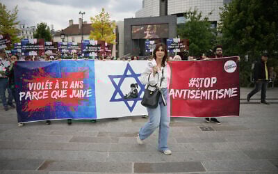 Photo d'illustration : Des manifestants tenant une banderole "violée à 12 ans parce que juive" lors d'une manifestation à l'appel d'associations dont SOS Racisme et la Fondation des femmes pour dénoncer l'antisémitisme, à Paris le 20 juin 2024, après le viol collectif antisémite d'une jeune fille de 12 ans à Courbevoie, dans la banlieue parisienne. (Crédit : Zakaria Abdelkafi/AFP)