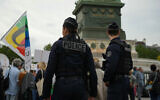 Des policiers surveillent une manifestation à l'appel d'associations comme SOS Racisme et la Fondation des femmes pour dénoncer l'antisémitisme, à Paris le 20 juin 2024, après le viol collectif antisémite d'une jeune fille de 12 ans à Courbevoie, en banlieue parisienne. (Crédit : Zakaria ABDELKAFI / AFP)