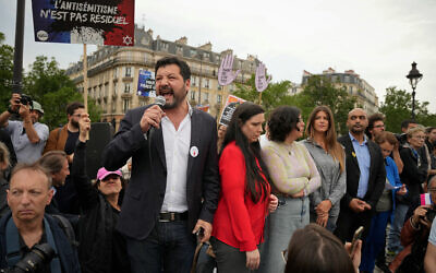 L'avocat français et vice-président de la Ligue des droits de l'Homme, Arié Alimi, prenant la parole lors d'une manifestation organisée par des associations, dont SOS Racisme et la Fondation des femmes, pour dénoncer l'antisémitisme, à Paris, le 20 juin 2024. Cette manifestation fait suite au viol collectif antisémite d'une jeune fille de 12 ans à Courbevoie, dans la banlieue parisienne. (Crédit : Zakaria Abdelkafi/AFP)