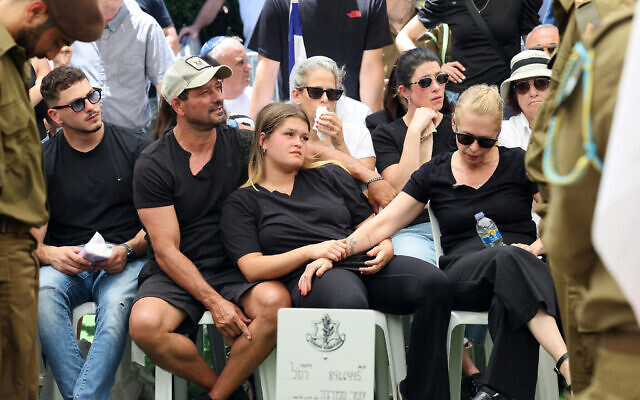 De gauche à droite : Son frère Rom, son père Oren, sa sœur Rotem et sa mère Liat Smadga lors des funérailles du sergent première classe Omer Smadga, 25 ans, au cimetière militaire de Netanya, le 21 juin 2024. (Crédit : Jack Guez/AFP)
