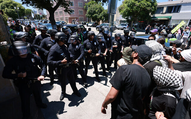 Des agents de la police de Los Angeles (LAPD) retenant des manifestants anti-Israël rassemblés devant la synagogue Adas Torah, empêchant l'accès à un événement sur l'investissement immobilier en Israël, à Los Angeles, le 23 juin 2024. (Crédit : David Swanson/AFP)